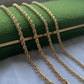 FOUR STRANDS OF ROPE CHAIN STYLED OVER A DARK GREEN JEWELLERY BOX.