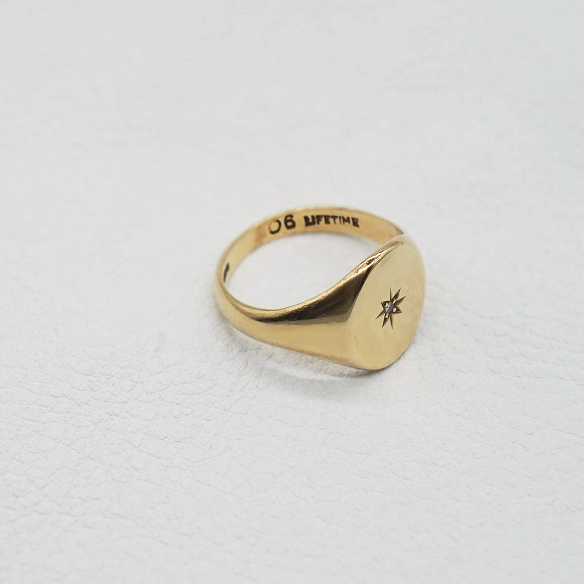 Side profile vintage 9k gold oval face signet ring- diamond in starburst setting in the centre of the face. Hallmarks can be seen on inner band
